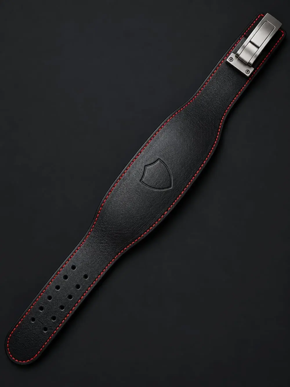 The finished black leather lever lifting belt with red edge stitching, the shield emblem on the back panel as in the drawing.