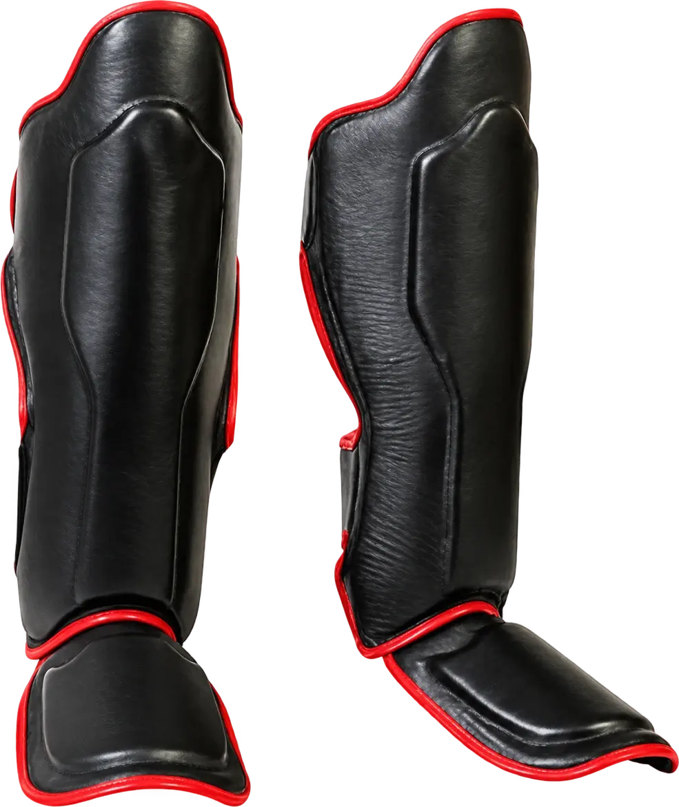 A pair of black shin-and-instep guards with red piping, a raised panel down each shin and a padded instep cover.